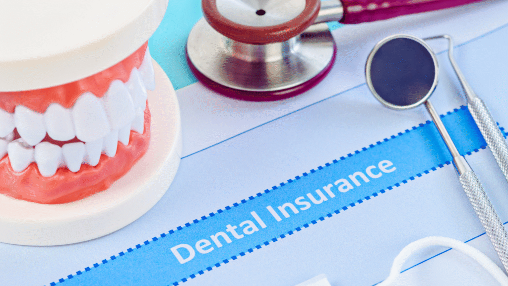 Image of a dental model with teeth, a stethoscope, and dental tools on a paper labeled "Dental Insurance," symbolizing dental health coverage and care.