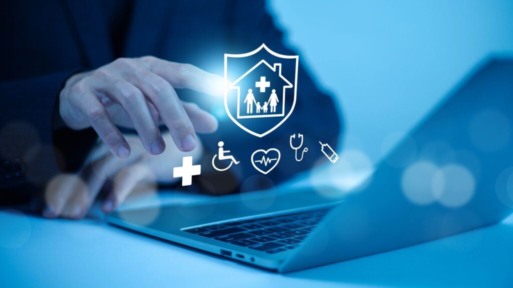Image promoting health insurance with a hand on a laptop, featuring a shield with a family icon and health symbols like a cross and heart, emphasizing comprehensive coverage.